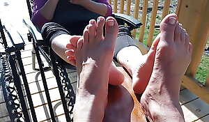 Playing footsie on the respecting porch wide our pedicured toes
